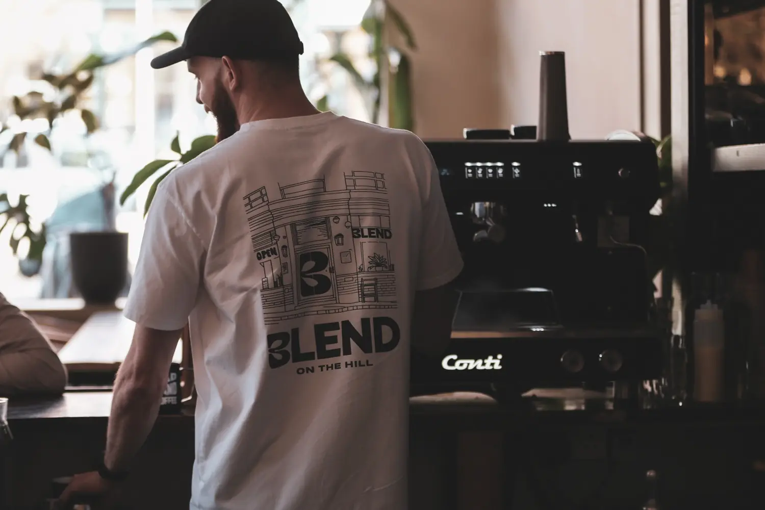 Barista in a Blend tee at the Conti espresso machine