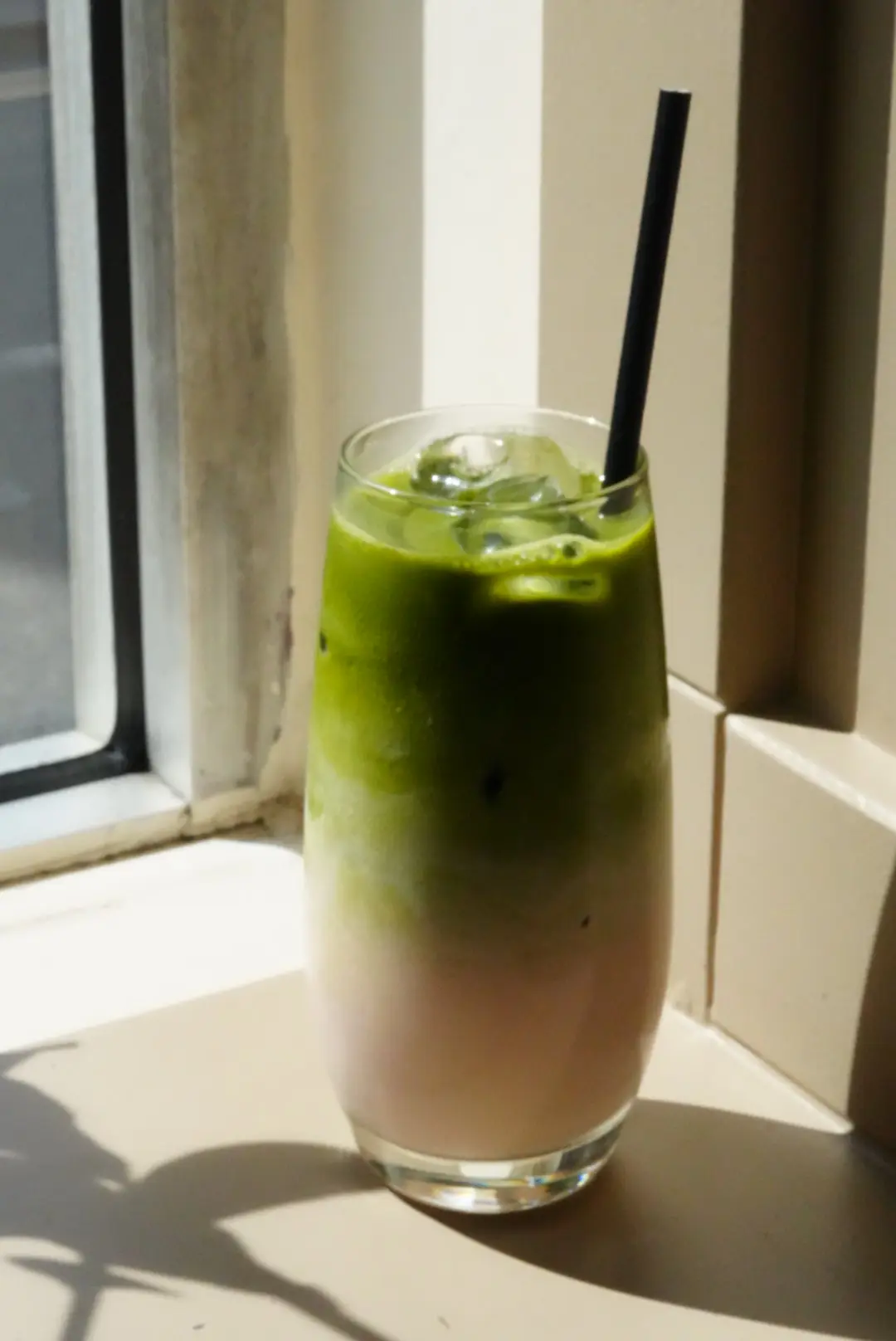 Iced matcha glass on a sun-lit table