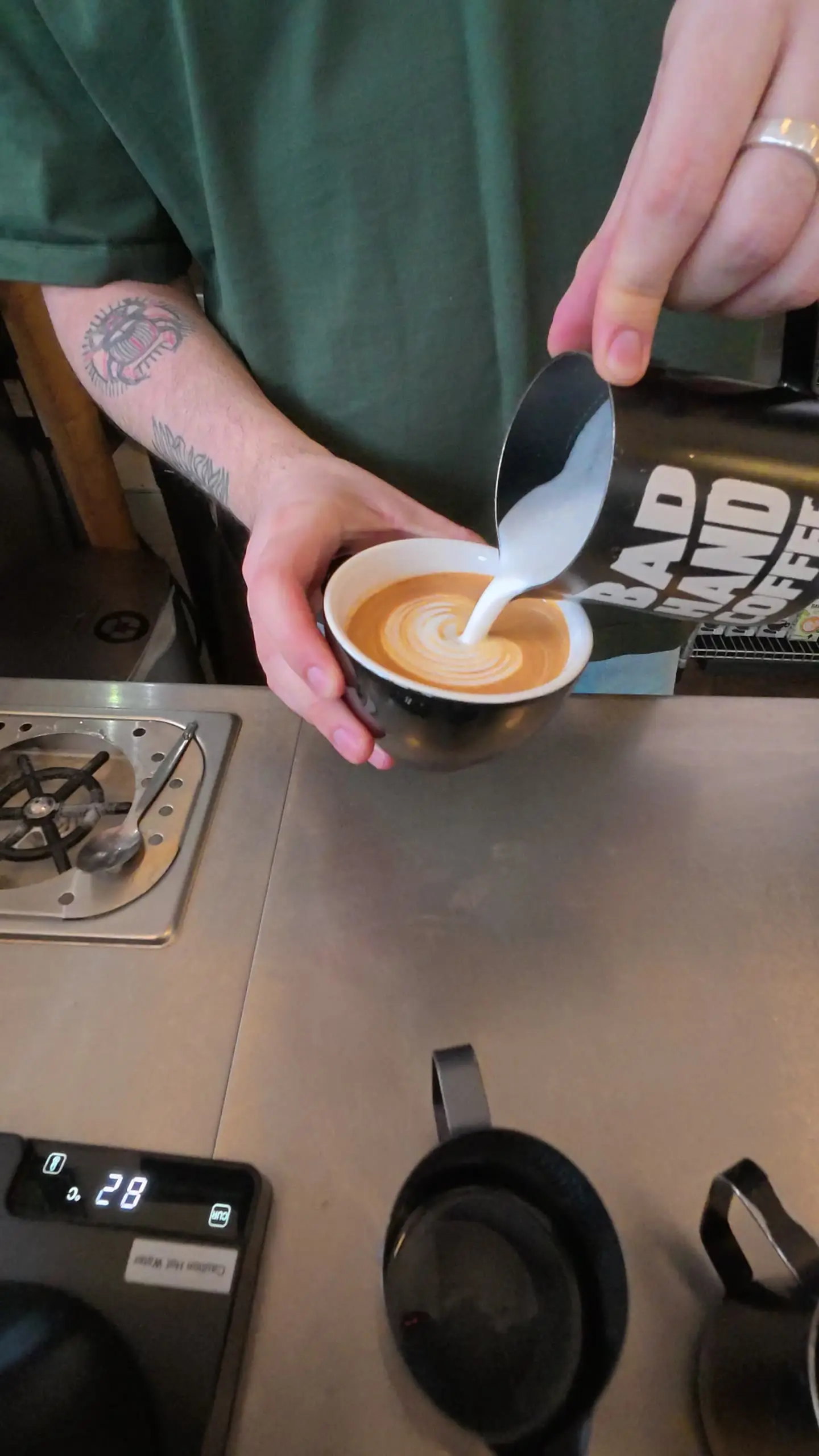 Latte being poured in a stoneware cup