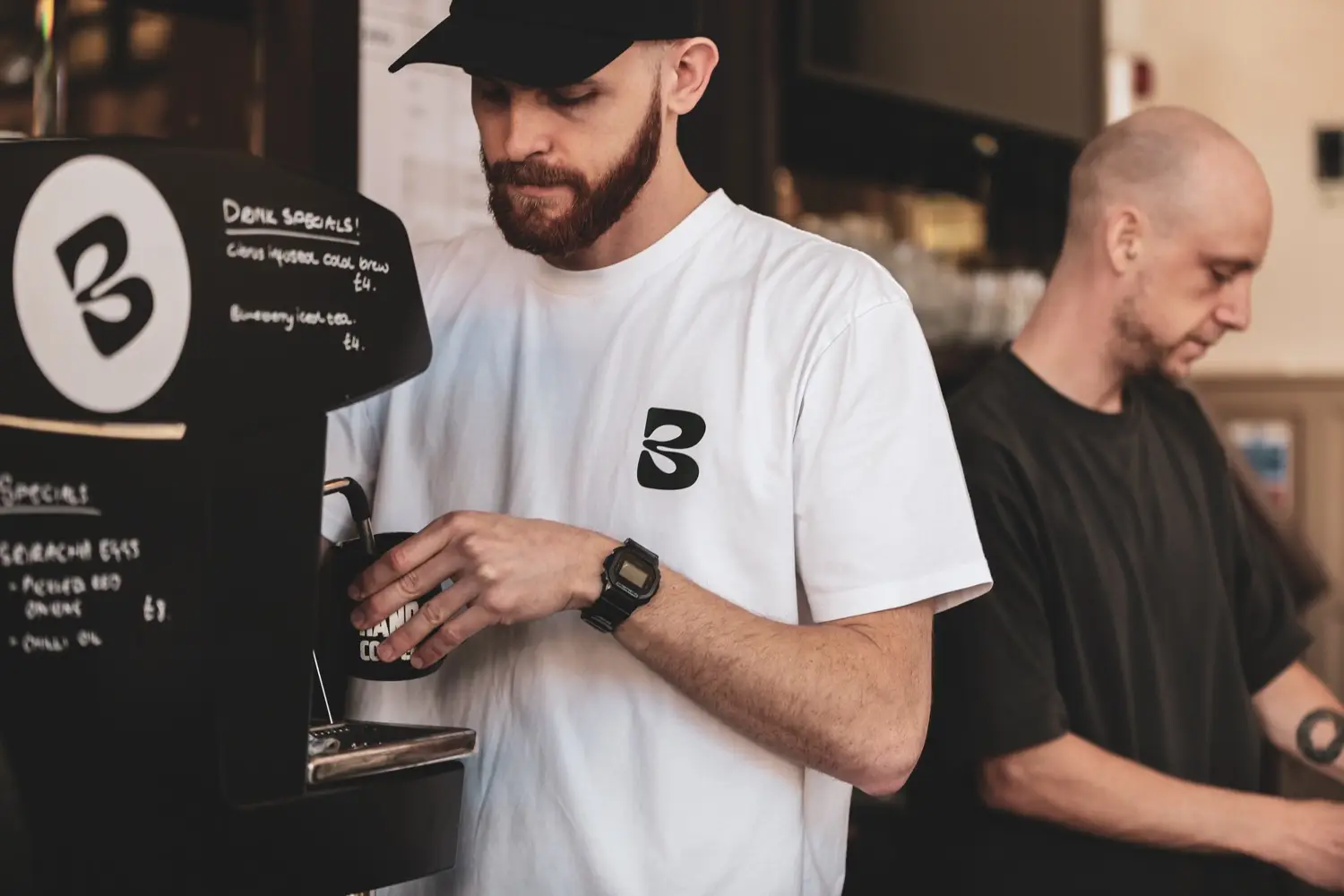 Two baristas working the bar in Blend tees